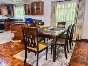 a kitchen with a dining room table with chairs at Greenpark Staycations in Athi River