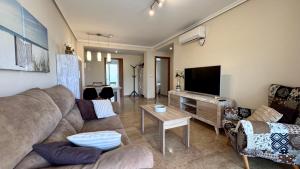 a living room with a couch and a flat screen tv at Residencial Ronda Mar in Denia
