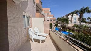 a balcony with two chairs and a swimming pool at Residencial Ronda Mar in Denia