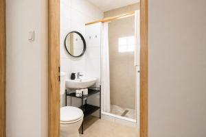 a bathroom with a toilet and a sink and a mirror at Héthajnal Apartman in Debrecen
