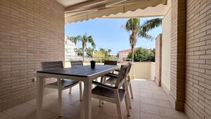 a table and chairs on a patio with palm trees at Residencial Ronda Mar in Denia