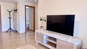 a living room with a flat screen tv on a wooden entertainment center at Residencial Ronda Mar in Denia +56 photos