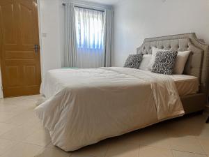 a bedroom with a large bed with a white comforter at Greenpark Staycations in Athi River