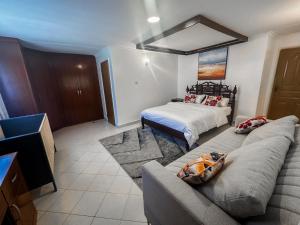 a living room with a couch and a bed at Greenpark Staycations in Athi River