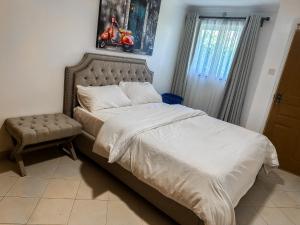 a bedroom with a large bed and a chair at Greenpark Staycations in Athi River