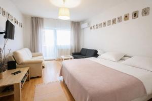 a hotel room with a large bed and a couch at Héthajnal Apartman in Debrecen