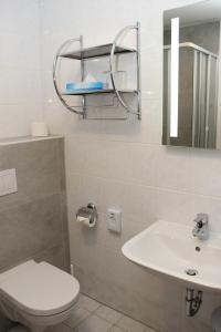 a bathroom with a white toilet and a sink at Pension Der kleine Nachbar in Gotha +14 photos