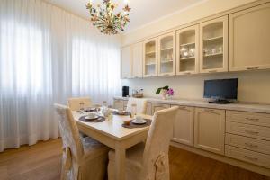 a kitchen with a table with chairs and a television at Residenza Maria Luisa in Padova
