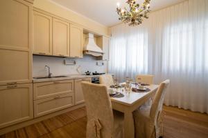 a kitchen with a table with chairs and a sink at Residenza Maria Luisa in Padova +17 photos