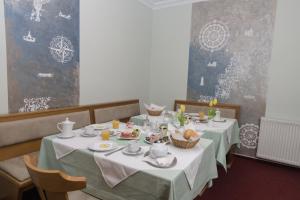 a dining room with a table with food on it at Pension Der kleine Nachbar in Gotha