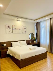 a bedroom with a large bed with white sheets at Son Tra homestay in Danang