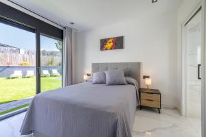 a bedroom with a bed and a large window at La Villa del Roc in Roda de Bará +28 photos