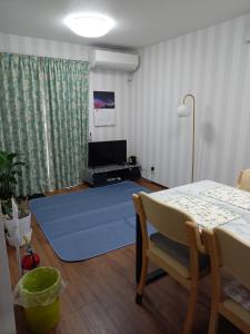 a living room with a table and a blue rug at ミエル富士 in Oishi