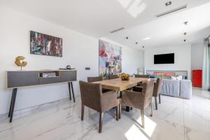 a dining room with a wooden table and chairs at La Villa del Roc in Roda de Bará