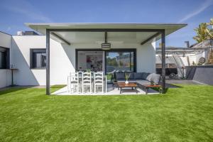 a patio with a couch and chairs in a yard at La Villa del Roc in Roda de Bará