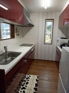 a kitchen with a sink and a counter top at ミエル富士 in Oishi