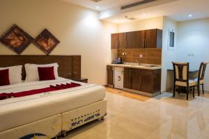 a bedroom with a bed and a kitchen with a sink at Golden New Hira Serviced Apartments in Jeddah