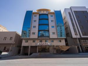 a tall building with blue windows in a city at Golden New Hira Serviced Apartments in Jeddah