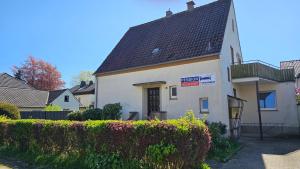 a small white house with a black roof at Pension Highway - Bünde Carl Diem Straße 46 in Bünde