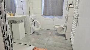 a white bathroom with a toilet and a sink at Pension Highway - Bünde Carl Diem Straße 46 in Bünde