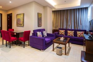 a living room with purple couches and a table at Golden New Hira Serviced Apartments in Jeddah