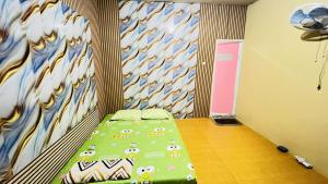 a bedroom with a bed with a green comforter at Bintang Sawarna 2 By ARBA in Sawarna