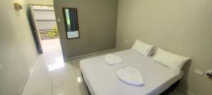 a bedroom with a white bed with two pillows at Red Palm Hotel in Suva