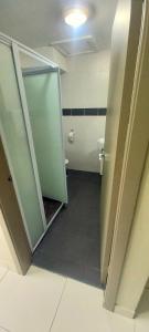 a bathroom with a toilet and a glass door at Red Palm Hotel in Suva