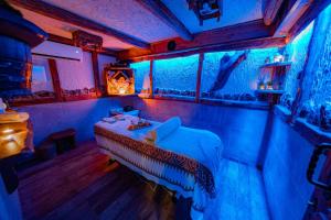 a room with a bed with blue and pink lights at Complex Starite Kashti in Razvalini Balchikioy