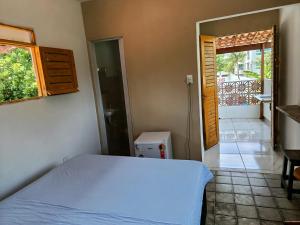 a bedroom with a bed and a door to a balcony at Kitnet com veranda in Conde