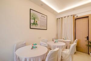 a room with two tables and white chairs at Treebo Premium Inn 62 in Noida