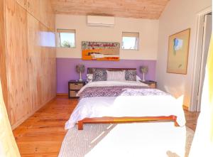 a bedroom with a bed and purple walls at Airconditioned Apartment for 3 guests. in Hermanus