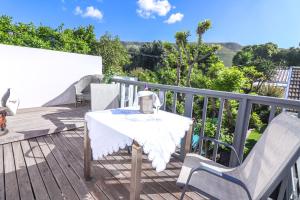 a table and two chairs on a deck at Airconditioned Apartment for 3 guests. in Hermanus