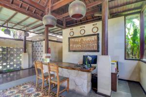a kitchen with two chairs and a counter with clocks on the wall at Palette Resort Argya Santi Jimbaran in Jimbaran