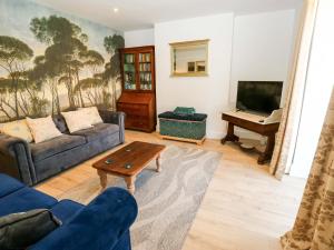 a living room with a couch and a piano at Stewards House in Tadcaster