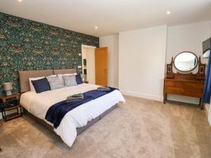 a bedroom with a large bed and a mirror at Stewards House in Tadcaster