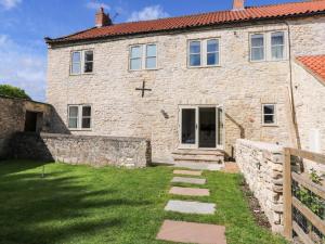 a stone house with a cross on the front of it at Stewards House in Tadcaster