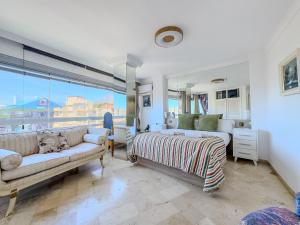 a bedroom with a couch and a bed and a window at Parque Marbella Three Bedroom Apartment in Marbella +38 photos