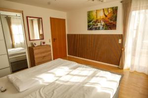 a bedroom with a large white bed in a room at Ferienwohnung Schwarzalb in Untere Mühlbauern