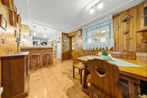 a kitchen with wooden walls and a table and chairs at Chata Danube in Gabčíkovo
