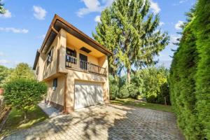 a house with a balcony and a driveway at Chata Danube in Gabčíkovo