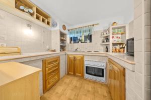 a large kitchen with wooden cabinets and a stove at Chata Danube in Gabčíkovo +6 photos