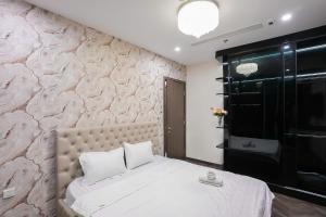 a bedroom with a white bed with a stone wall at Shi House -Modern Luxury 2BR Apartment BE3 Beverly in Ấp Thạnh Lộc