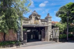 an entrance to a stone building with trees at Palette Resort Argya Santi Jimbaran in Jimbaran