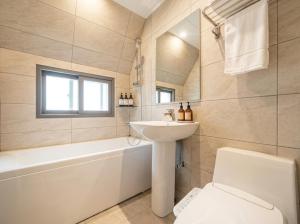 a bathroom with a sink and a toilet and a tub at Busan Station Iruda Hotel in Busan +15 photos