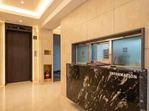 a lobby with a reception desk in a building at Busan Station Iruda Hotel in Busan