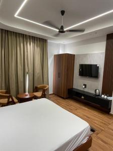 a bedroom with a bed and a flat screen tv at Purav Hotel in Kharkhauda +19 photos