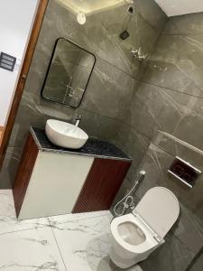 a bathroom with a sink and a toilet and a mirror at Purav Hotel in Kharkhauda