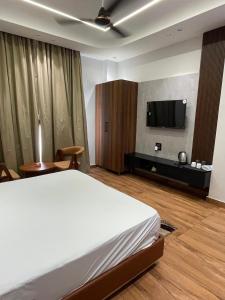 a bedroom with a bed and a flat screen tv at Purav Hotel in Kharkhauda