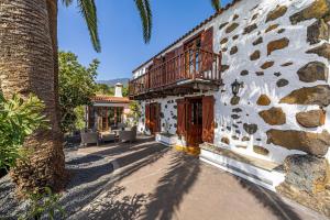 a building with a palm tree next to a street at Casa Piedra y Tea in Tijarafe